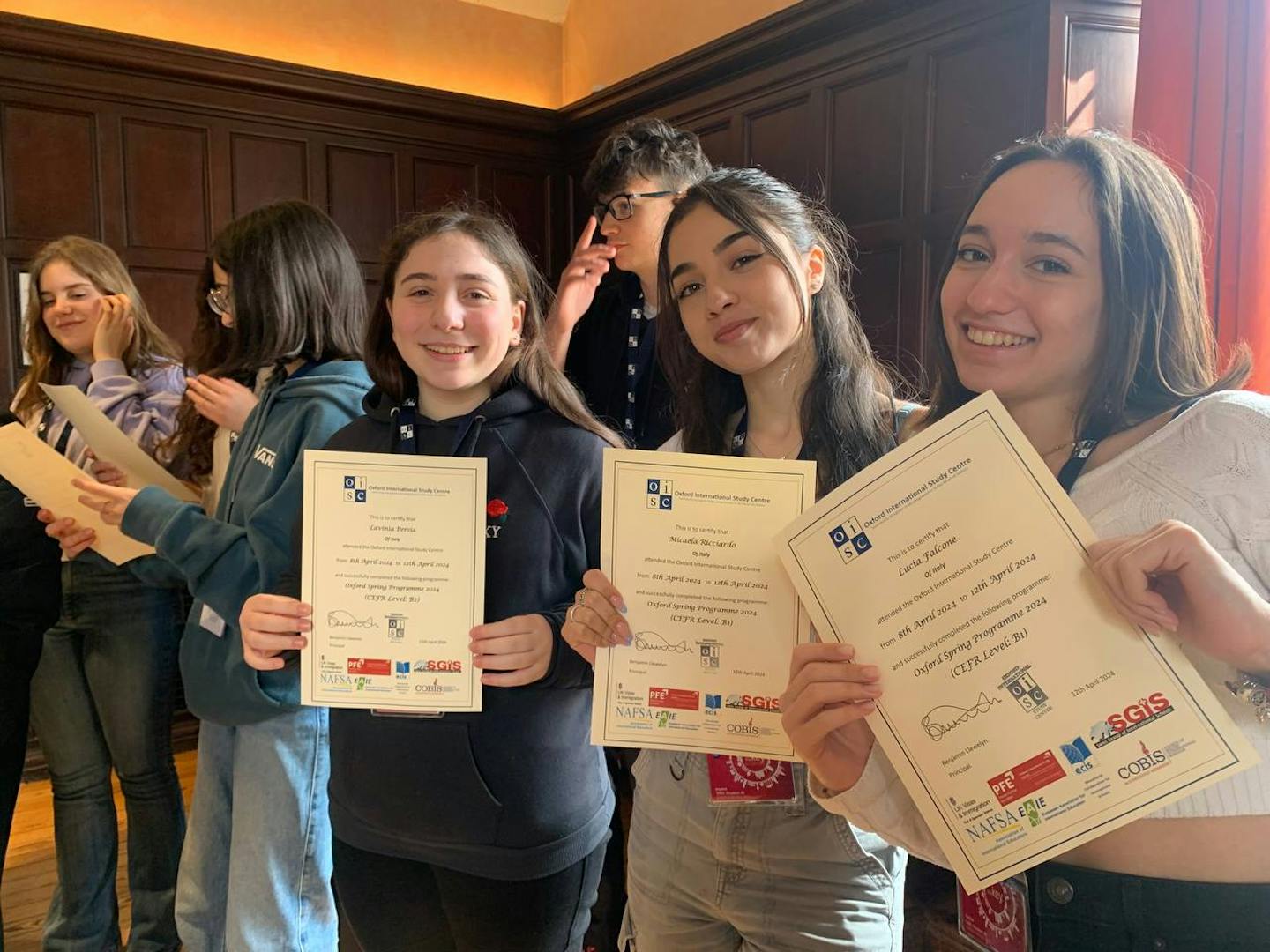 a group of smiling students holding up certificates